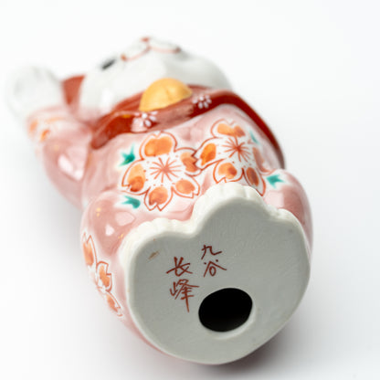 Underside of the pink Sakura lucky cat showing a round opening and red markings on the base.