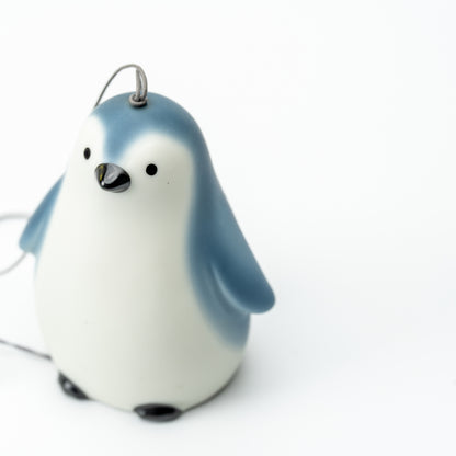 Yakushigama blue-and-white penguin wind chime with a black beak and a metal hanging loop.