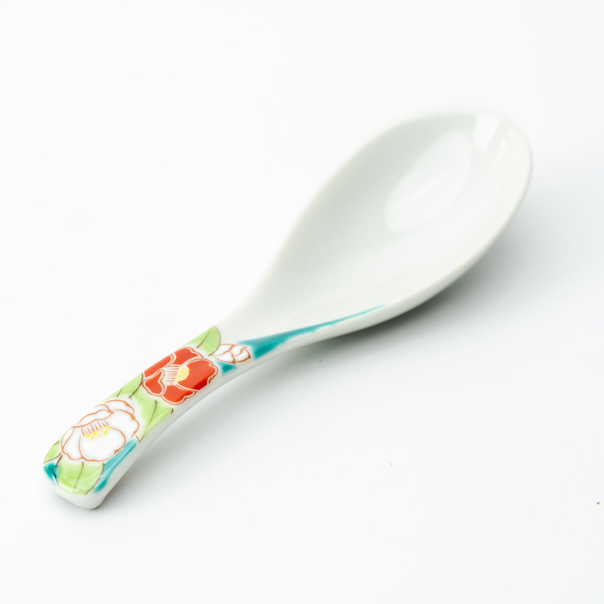 White Kutani soup spoon with red and pale flowers on a turquoise-accented handle.