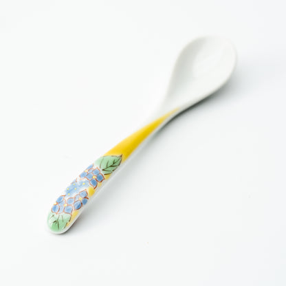 Kutani tea spoon with blue flowers and green leaves on a yellow handle.