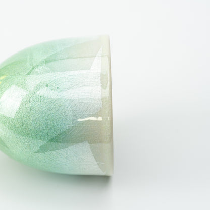 Close-up of the green Kutani wine cup's shimmering patchwork surface near the rim.