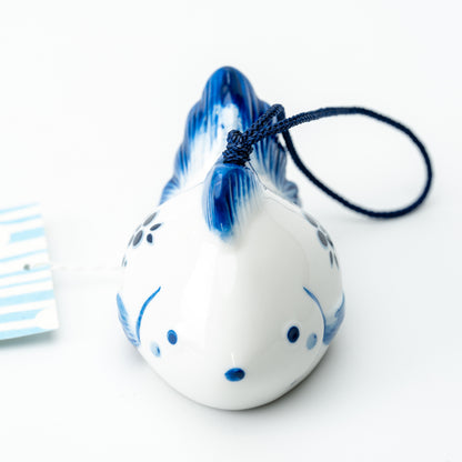 Front view of the white goldfish wind chime with a blue dorsal fin, small eyes and blue mouth.