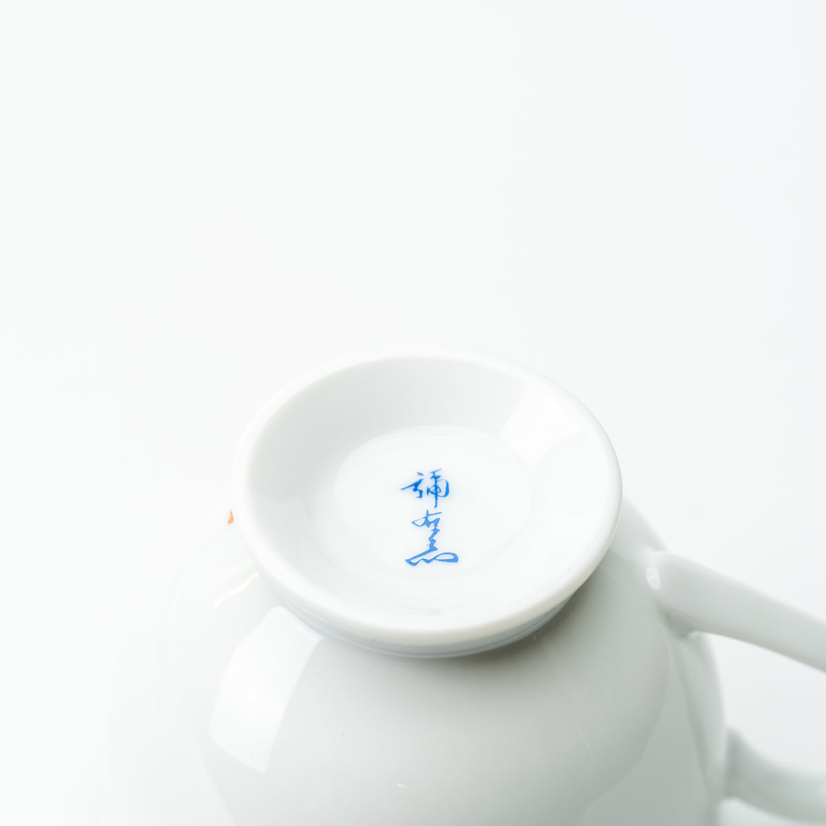 Underside of the plum blossom and bird cup with a blue maker's mark inside the white foot ring.