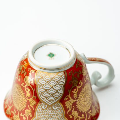 Underside of the red-and-gold chrysanthemum cup with a small green maker's mark in the foot ring.