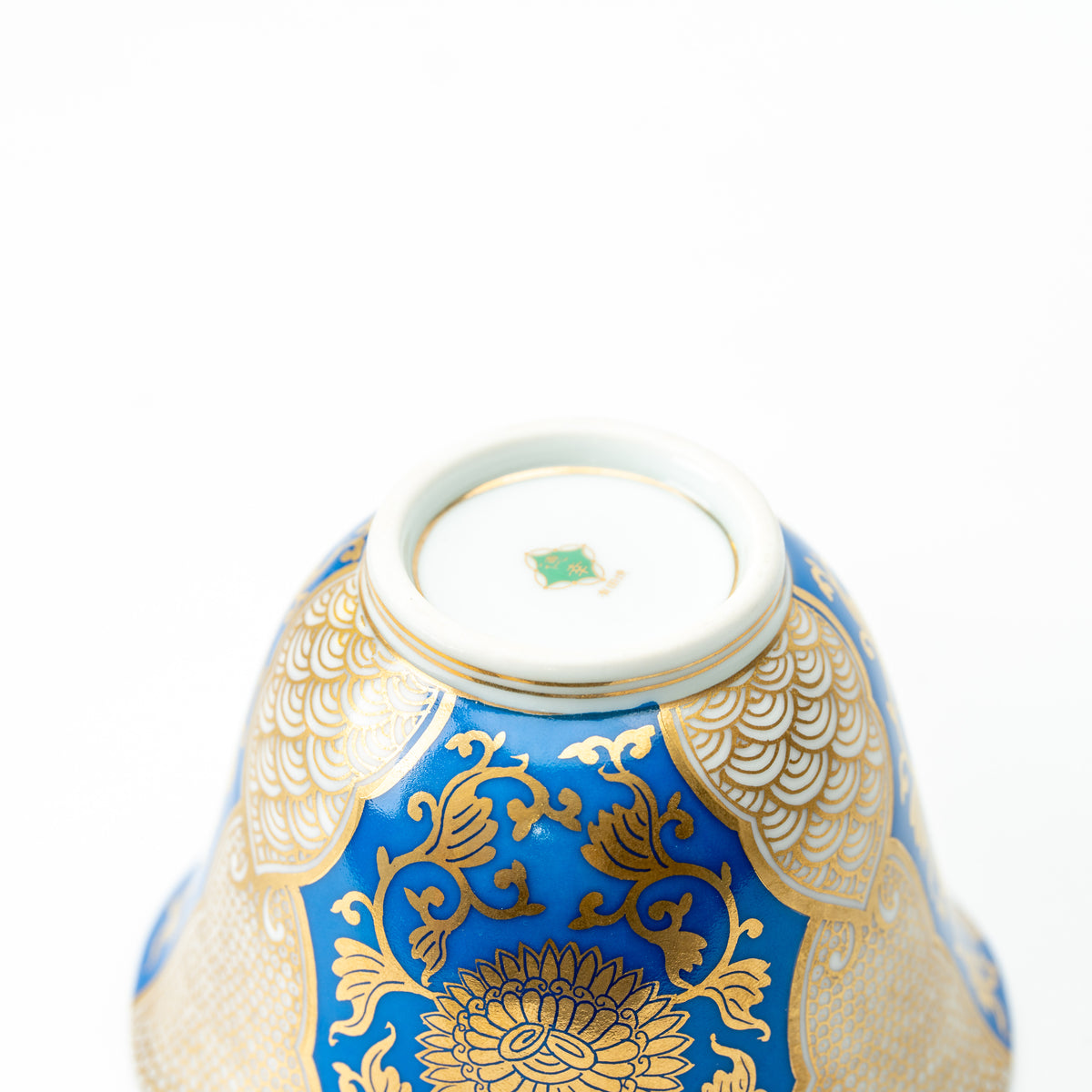 Underside of the blue-and-gold chrysanthemum cup, showing a green maker's mark within the foot ring.