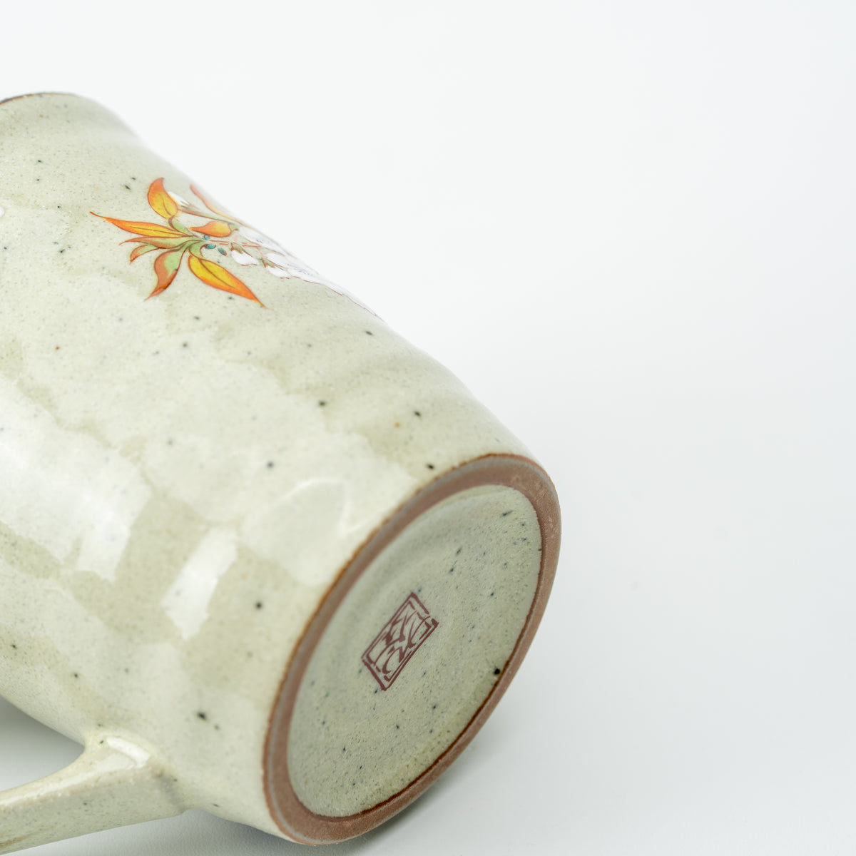 Underside of the bird and cherry blossom mug with a stamped maker's mark and brown foot ring.