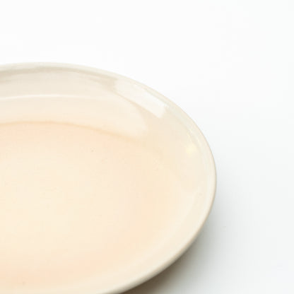 Close-up of the Hagi Himetsuchi saucer's pale peach center and softly shaded cream rim.