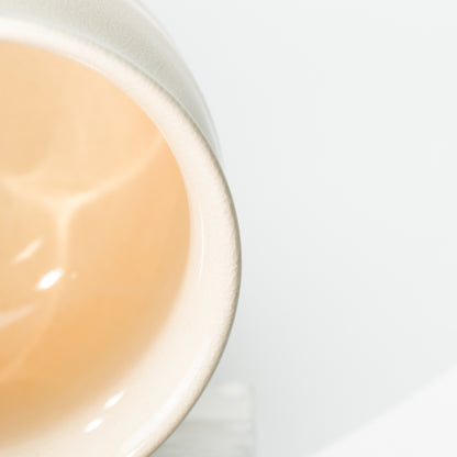 Close-up of the Hagi Himetsuchi cup's peach-colored interior and rounded pale rim.