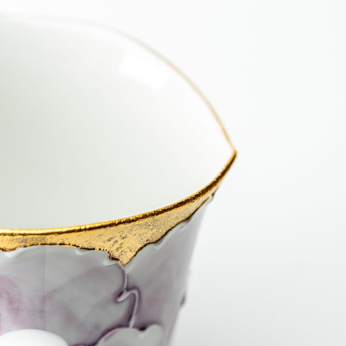 Detail of the purple Bunzan peony mug's scalloped gold-colored rim and white interior.