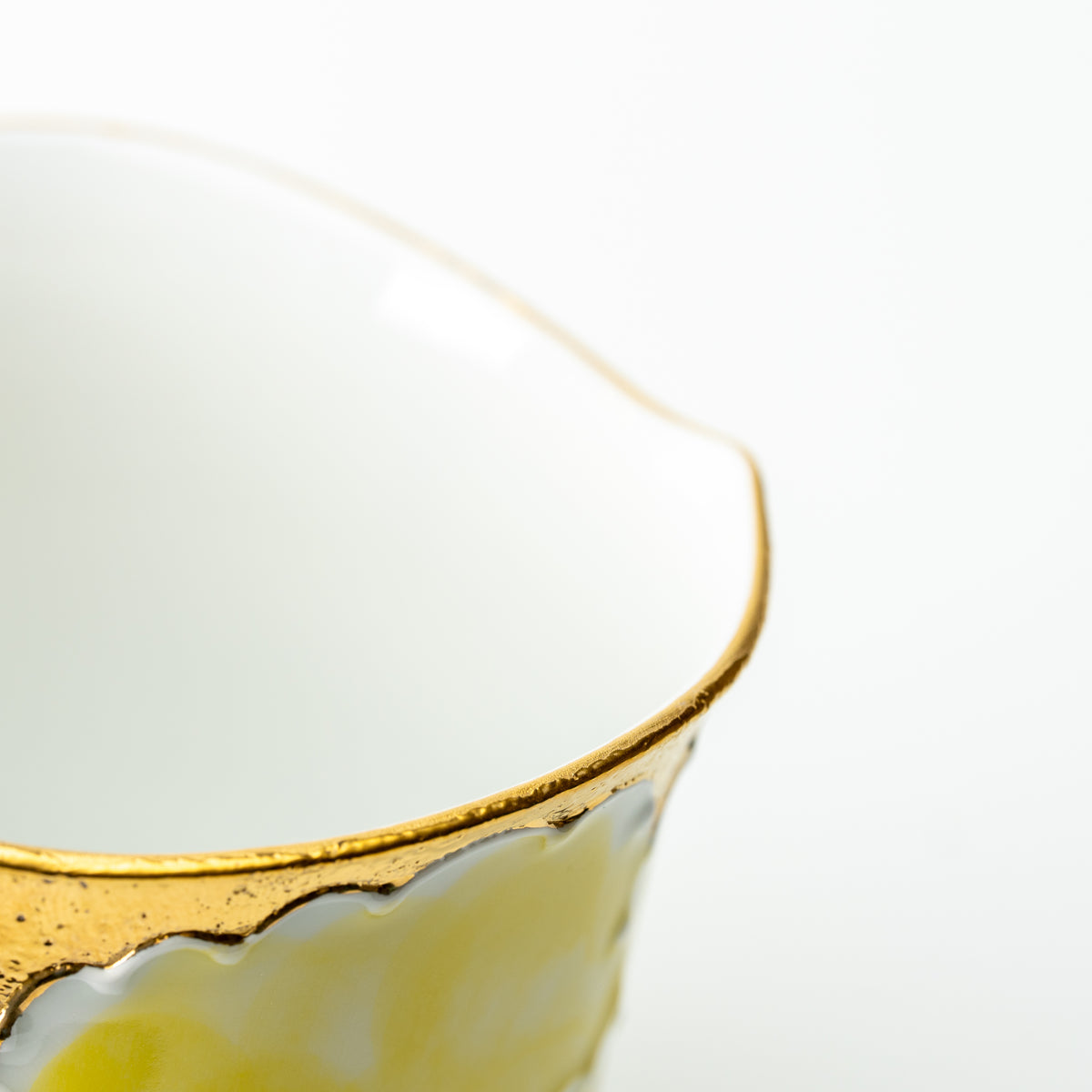 Detail of the yellow Bunzan peony mug's scalloped gold-colored rim and white interior.