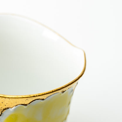 Detail of the yellow Bunzan peony mug's scalloped gold-colored rim and white interior.