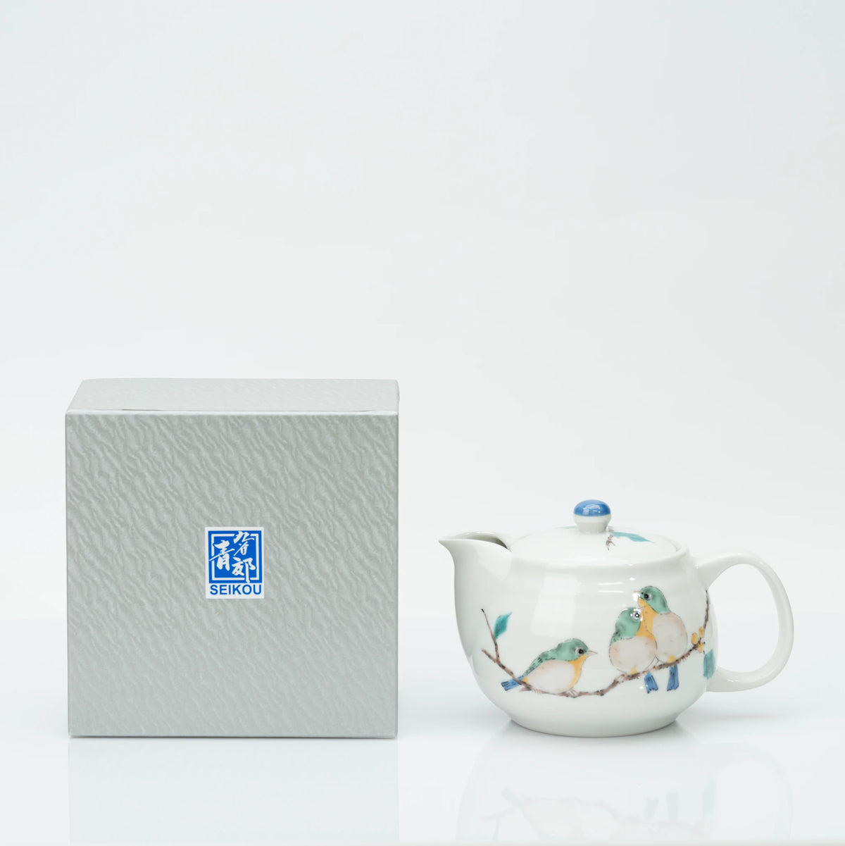 The teapot beside its grey Seikou Kiln gift box, showing how the piece arrives packed.