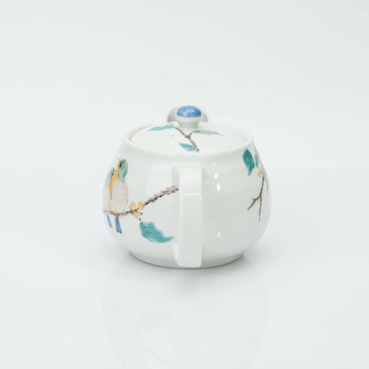 The Kutani teapot seen from behind, its loop handle and the berry branch carrying on around the body.