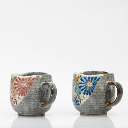 Side views of two Kutani mugs showing the grey glaze, handles and edges of the floral panels