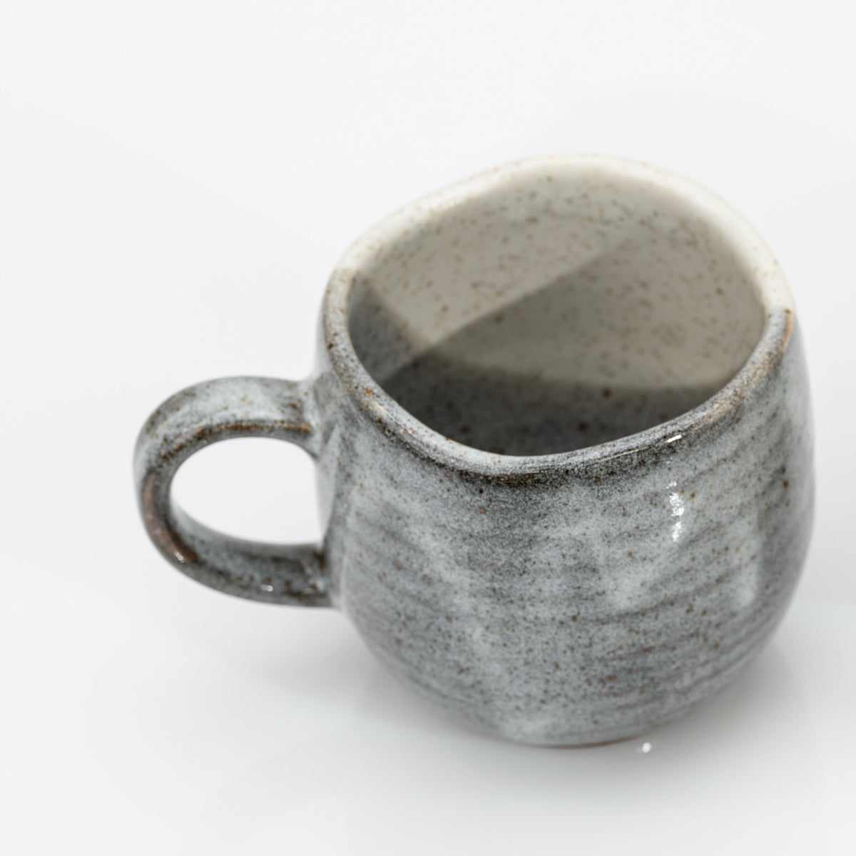 Kutani mug tilted to show the plain grey back and the glazed interior