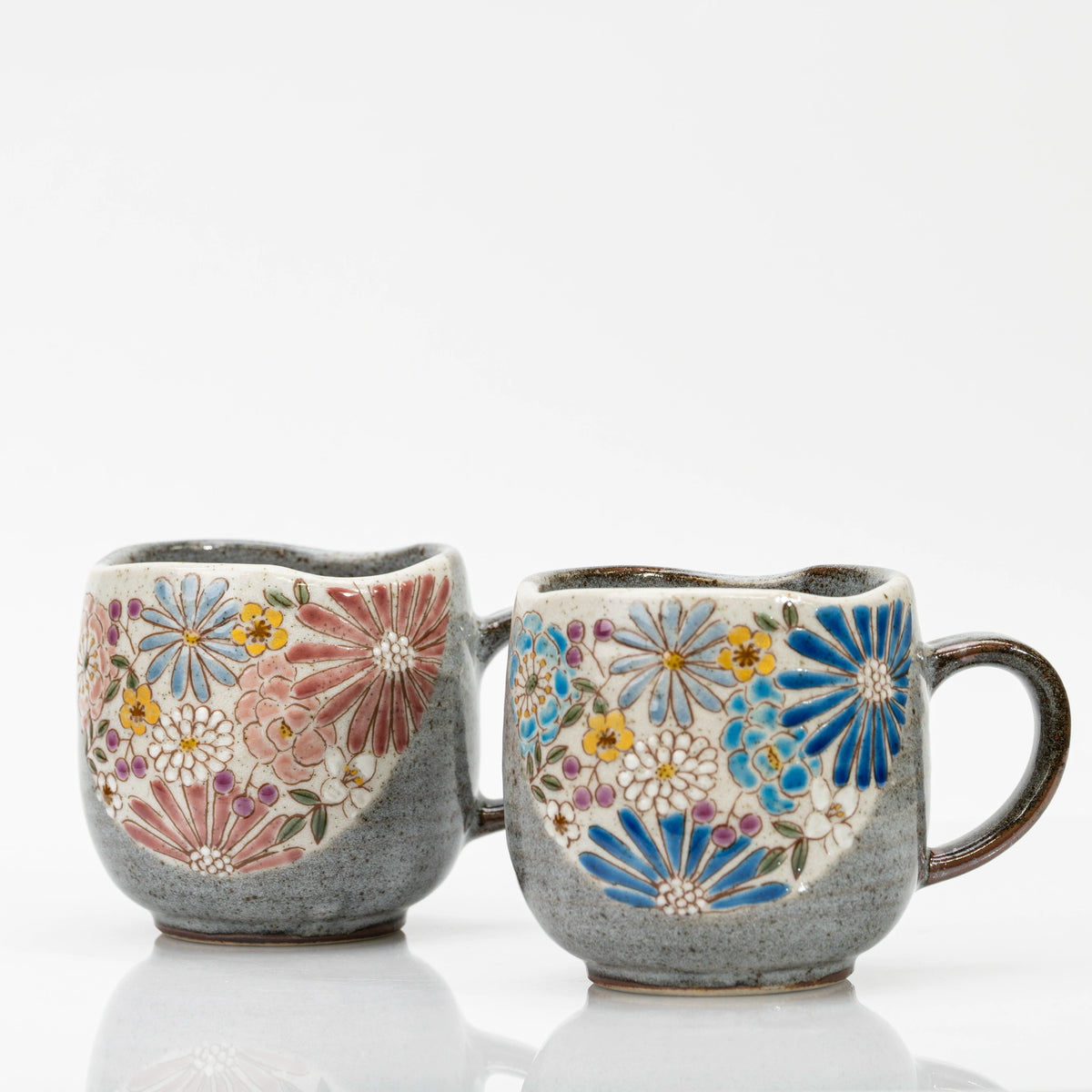 The red and blue Kutani mugs side by side, floral panels facing forward