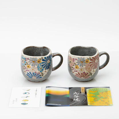 The red and blue Kutani mugs with printed leaflets laid in front