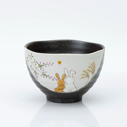 Kutani rice bowl with two rabbits and flowers painted on a cream panel