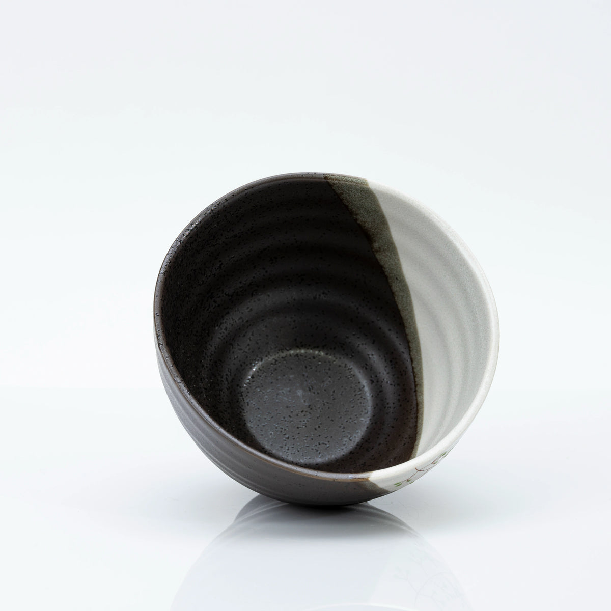Inside of the bowl, dark speckled glaze seen at an angle