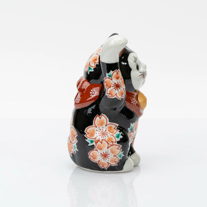Opposite side of the black lucky cat showing blossoms along its body and raised paw