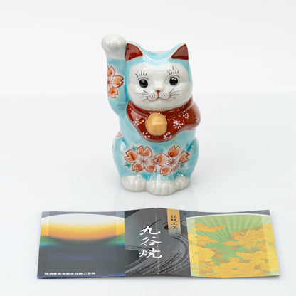 Front view of turquoise blue Kutani lucky cat with a Kutani ware leaflet