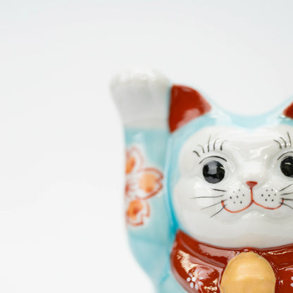 Close-up of the raised paw, white face, and turquoise blue glaze