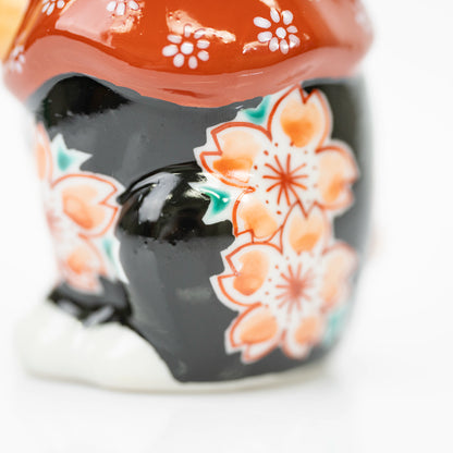 Close-up of peach-colored cherry blossoms on the cat's glossy black side