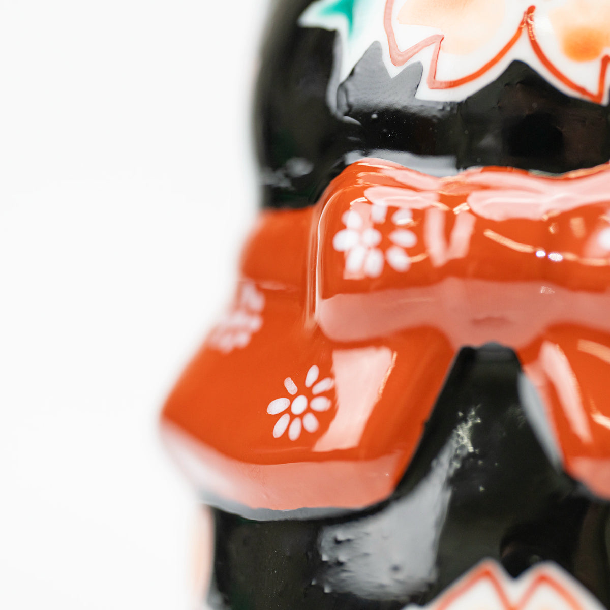 Close-up of the red floral bow on the back of the lucky cat