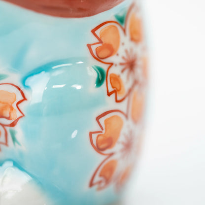 Close-up of the blue lucky cat's side and cherry blossom decoration