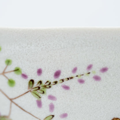 Close-up of a purple flowering branch beside the rabbits