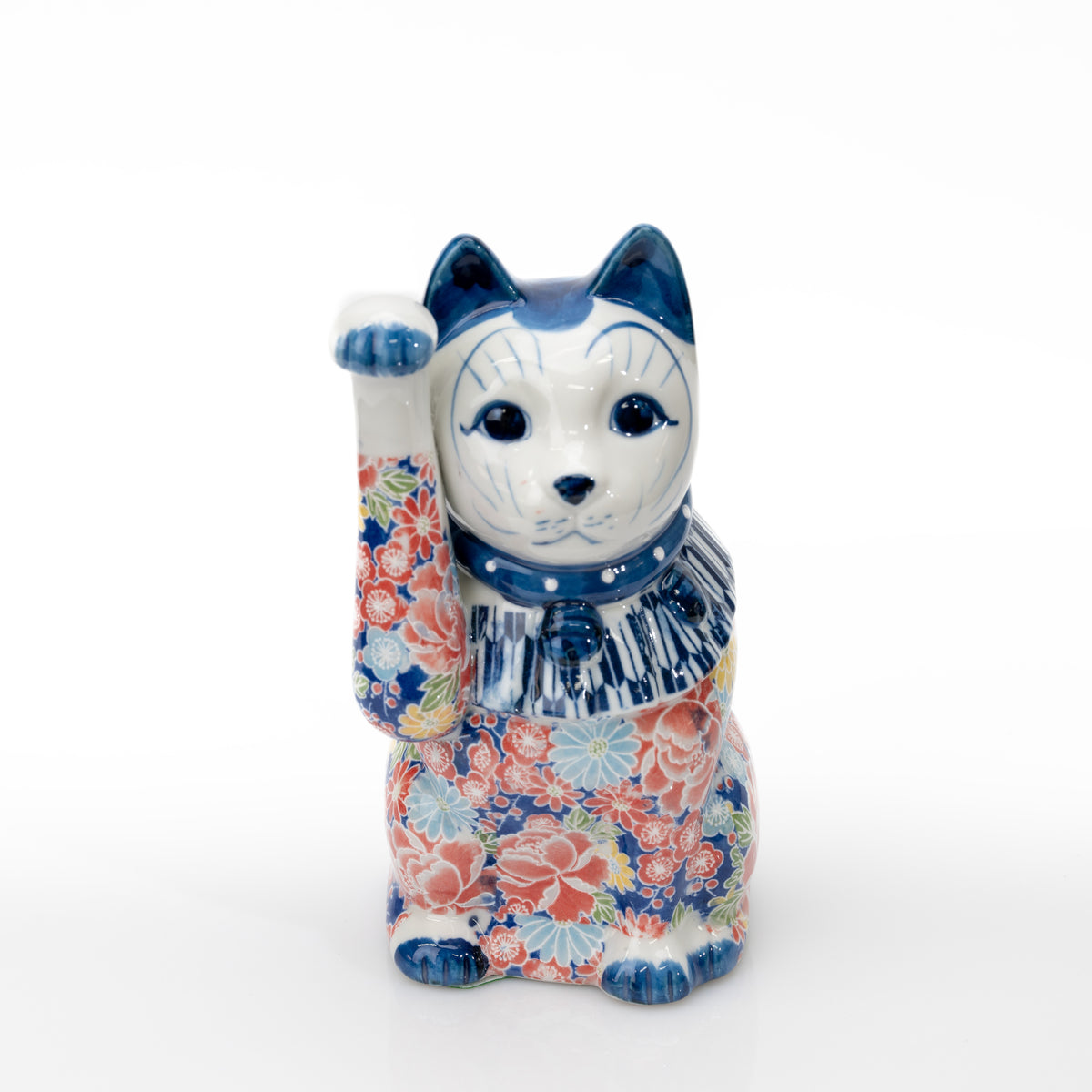 Vue de face d’un maneki-neko bleu en porcelaine Seto à décor floral, avec la patte droite levée, le visage blanc et un plastron rayé