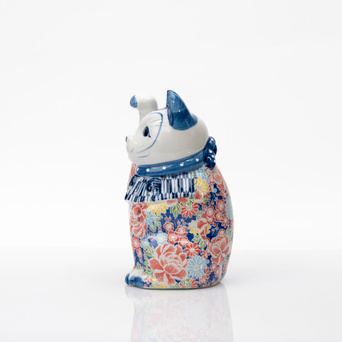 Vue de profil du chat bleu à décor floral, montrant le plastron rayé et les fleurs autour du corps