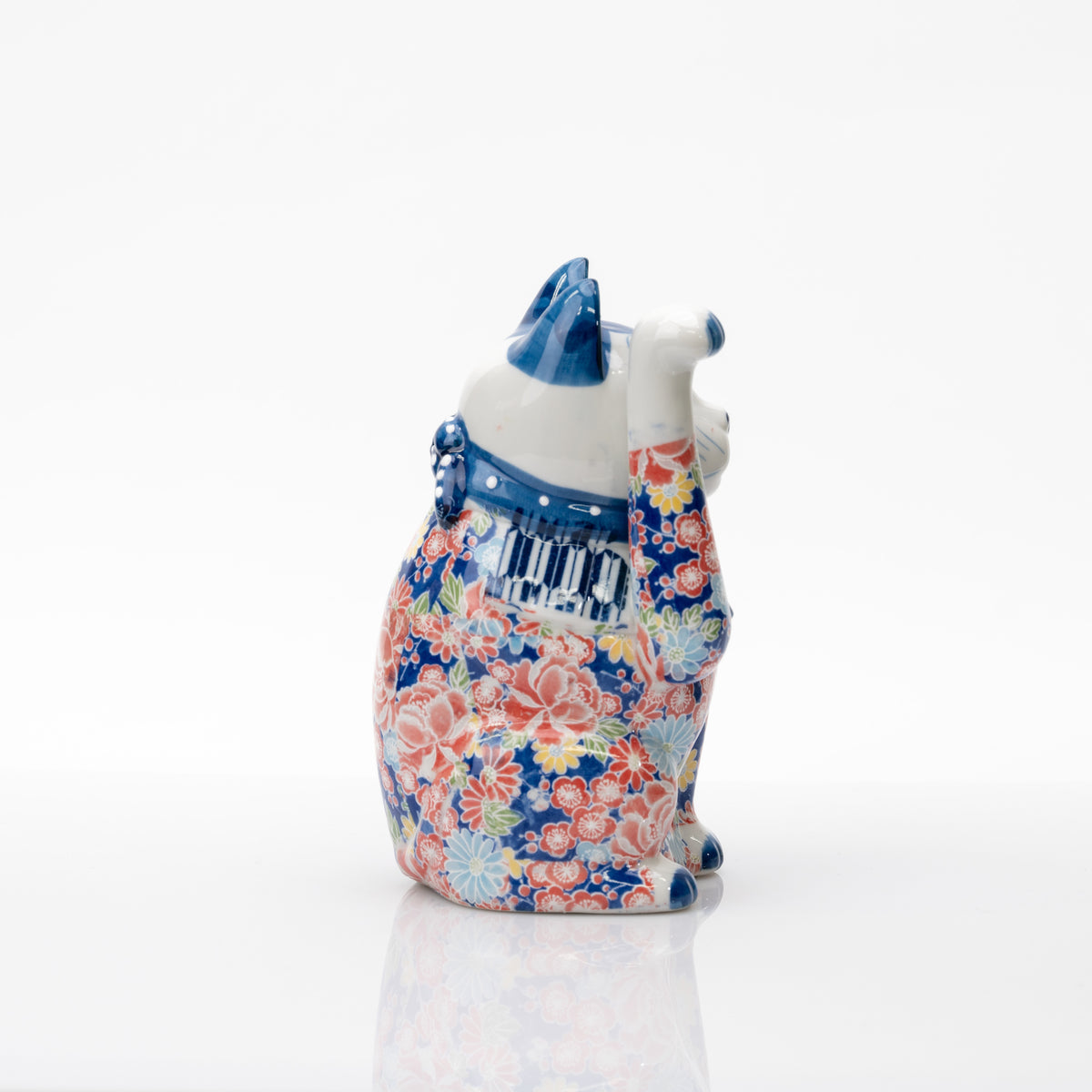 Autre profil du chat porte-bonheur, montrant sa patte droite levée bien haut et son décor floral