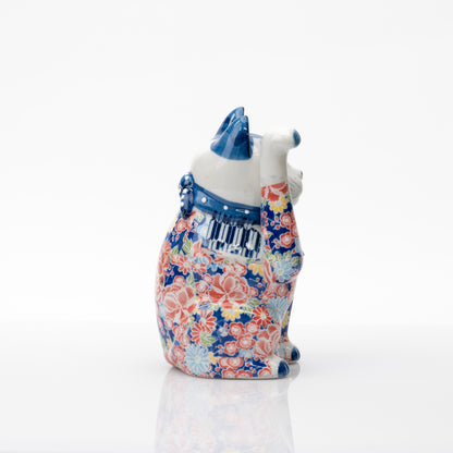 Autre profil du chat porte-bonheur, montrant sa patte droite levée bien haut et son décor floral