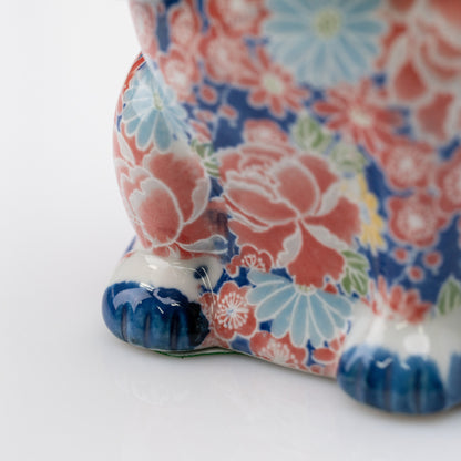 Détail de fleurs roses et bleu pâle à côté de la patte bleue du chat