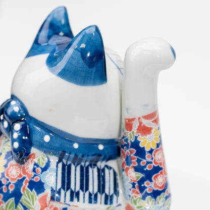 Détail de l’oreille bleue, de la patte droite levée, du motif floral et du plastron rayé, vus de profil