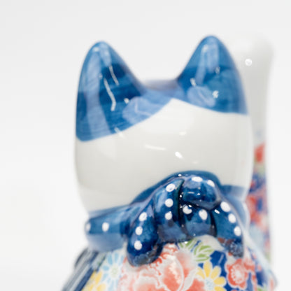 Arrière de la tête du chat et nœud bleu à côté de sa patte droite levée