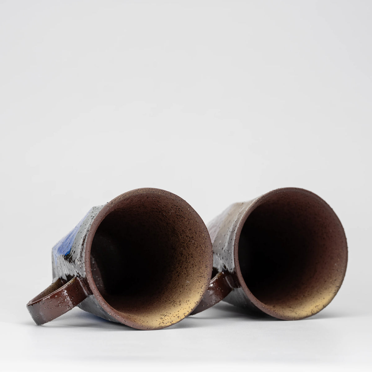 Blue and lilac ginsai mug pair, view from above showing the opening and interior.
