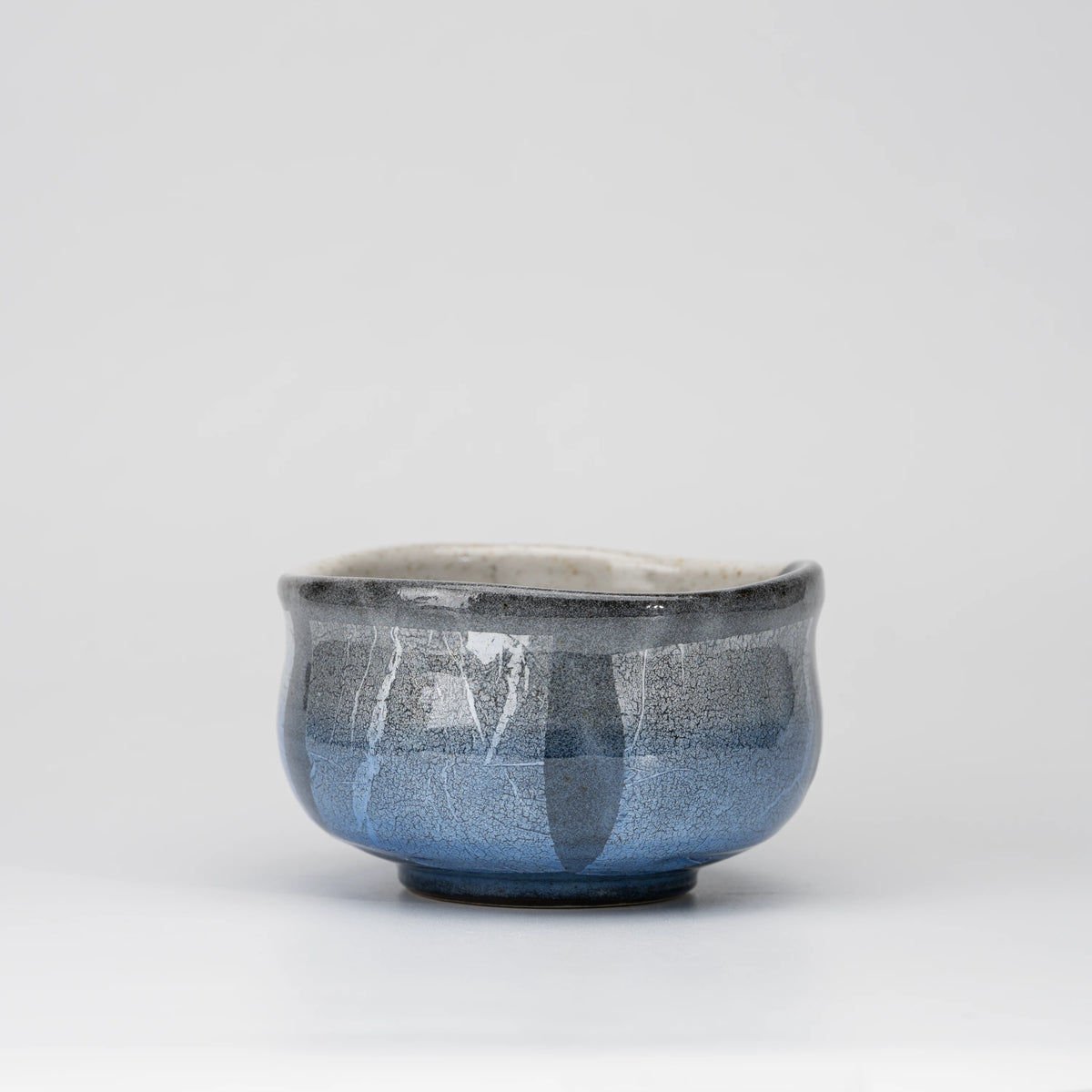 Blue ginsai matcha bowl, whole view on a neutral background.