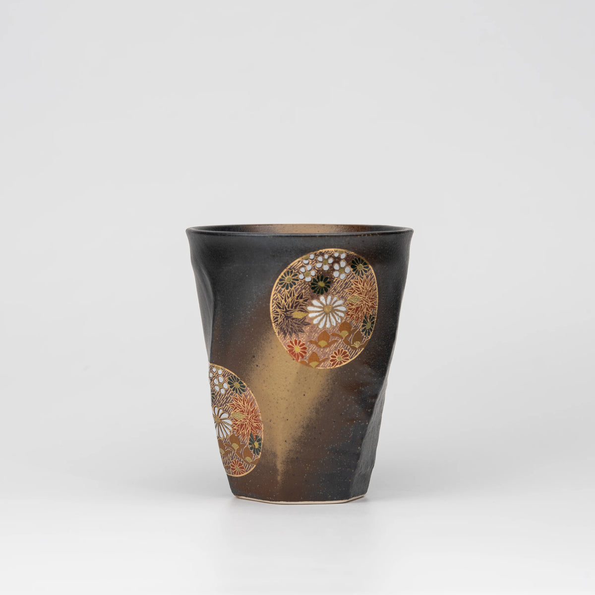 Dark floral medallion cup, whole view on a neutral background.