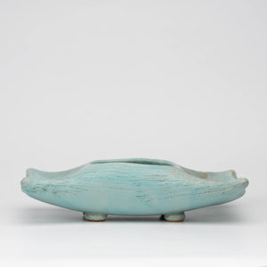 Pale blue mini ikebana vase, whole view on a neutral background.