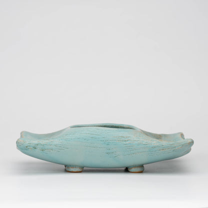 Pale blue mini ikebana vase, whole view on a neutral background.