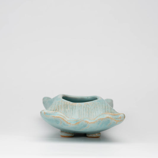 Pale blue mini ikebana vase, side view showing the shape and surface.
