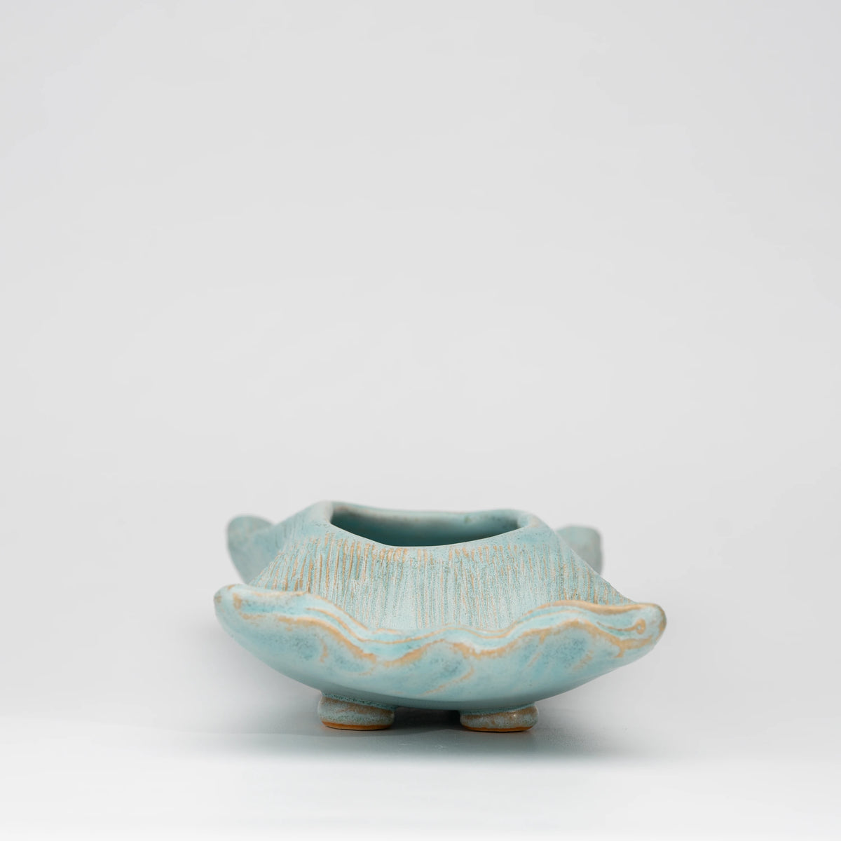 Pale blue mini ikebana vase, side view showing the shape and surface.