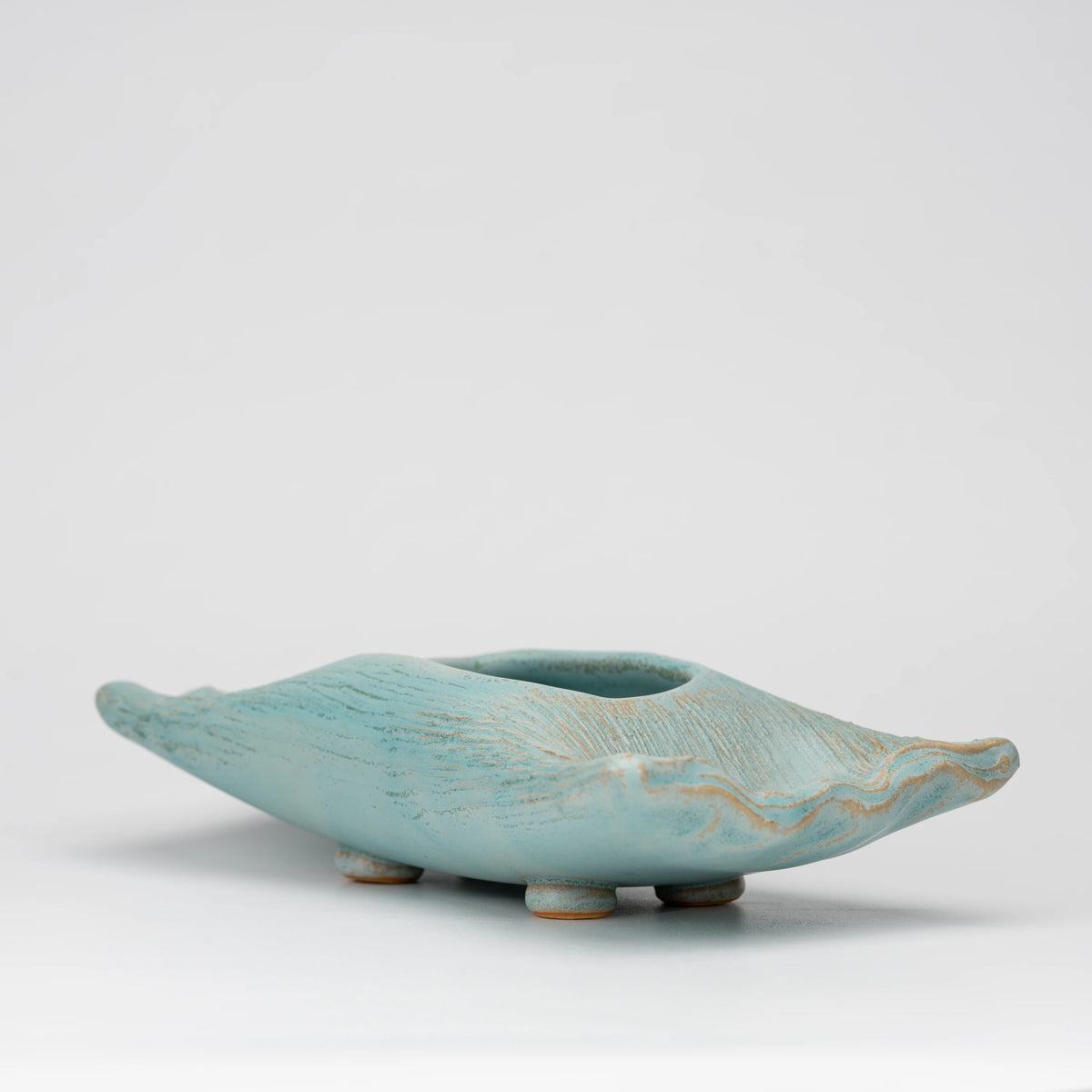 Pale blue mini ikebana vase, side view showing the shape and surface.
