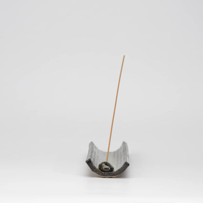 Green mosaic incense holder, whole view on a neutral background.