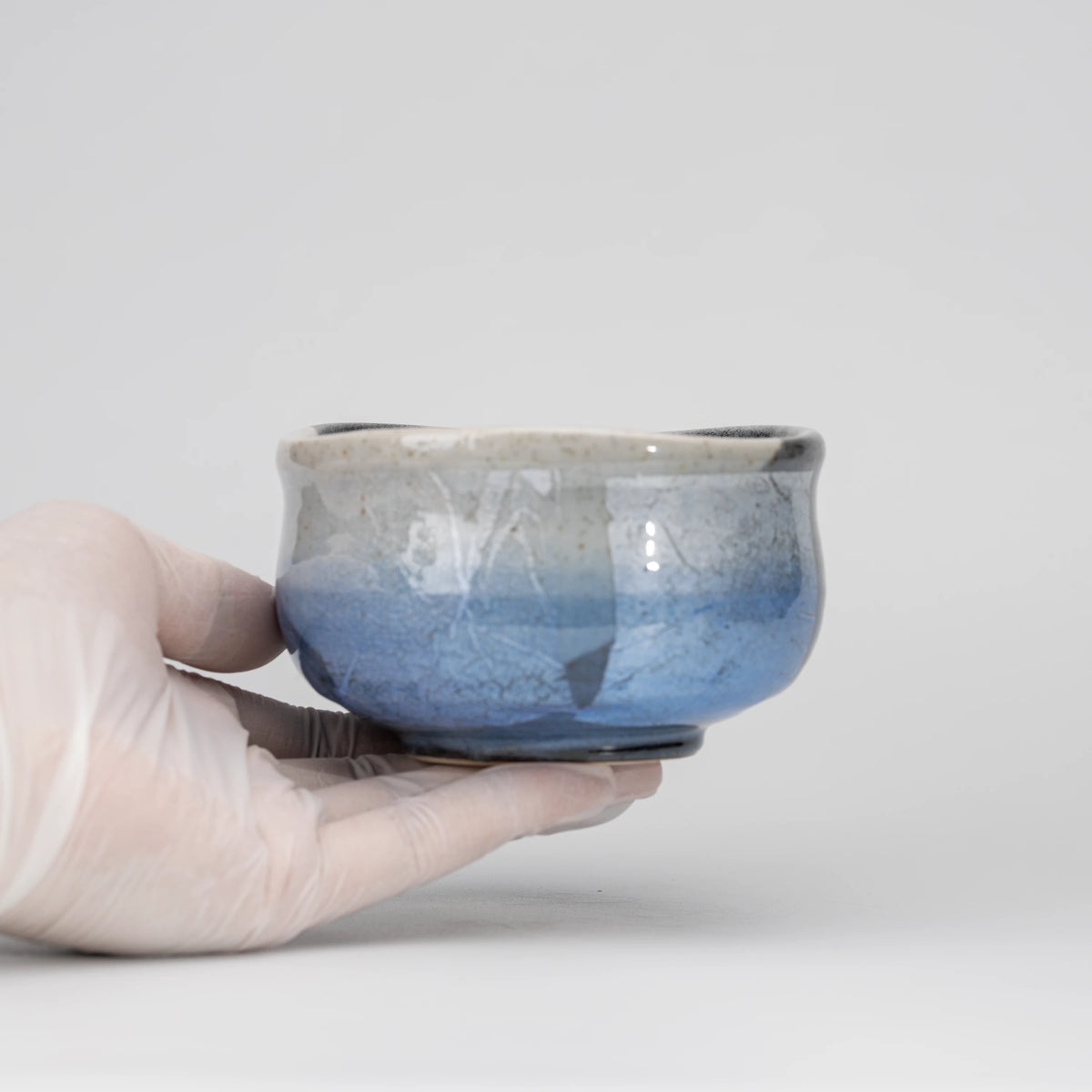Blue ginsai matcha bowl, held in a hand to show scale.