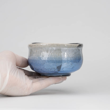 Blue ginsai matcha bowl, held in a hand to show scale.