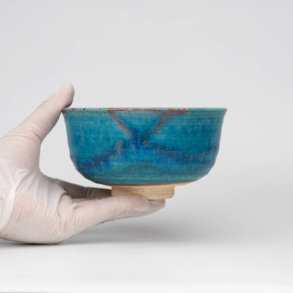 Blue Tsuyukusa matcha bowl, held in a hand to show scale.