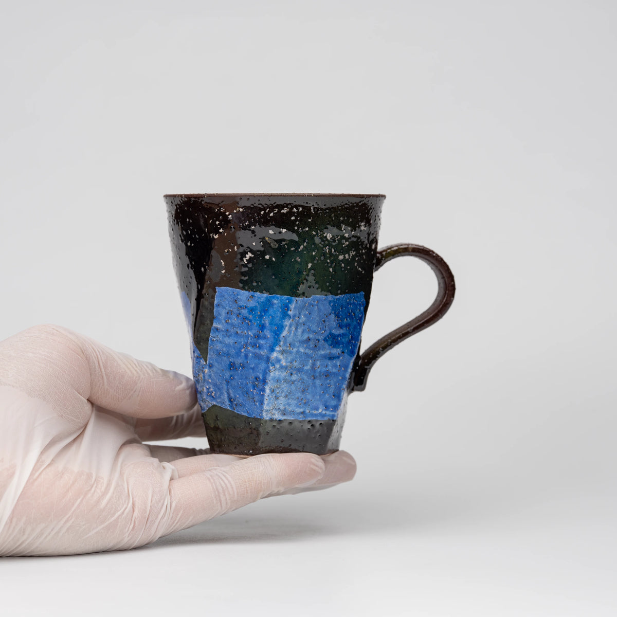 Blue ginsai mug, held in a hand to show scale.